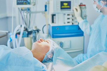 Several doctors surrounding patient on operation table during t