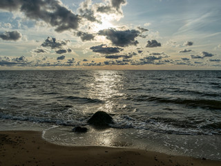 seascape image of the sea with  stones and grass of light before sunset,  quiet sea. baltic sea, Tuja beatch, Latvia