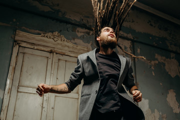 Emotion male portrait of man with dreadlocks in theater studio.