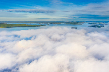 Aerial view of Pulkkilanharju Ridge, Paijanne National Park, southern part of Lake Paijanne. Landscape with drone. Fog, Blue lakes, fields and green forests from above on a sunny summer morning.