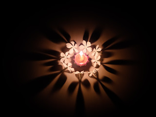 Happy diwali - diya lamp lit with white flowers during diwali festival celebration