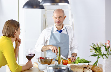 Smiling young couple cooking food in the kitchen