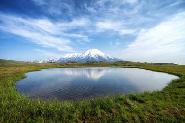 Volcano and lake with reflection in water in Russia on Kamchatka