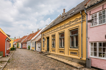 An idyllic street with cobblestone and colourful old houses on the danish island Aero