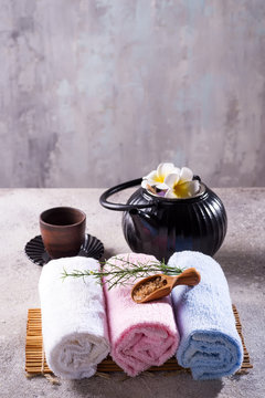 Color towels with green leaves, spoon of salt and detox tea on bamboo mat and stone table © YuliiaMazurkevych