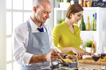 Smiling young couple cooking food in the kitchen