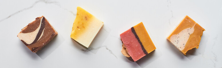 panoramic shot of natural homemade soap pieces on marble surface