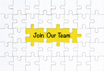 Join our team concept. White jigsaw puzzle with word and yellow background