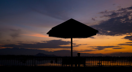 A silhouette of a umbrella against a gorgeous sunset