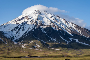 Beautiful autumn volcanic landscape - view of snow-capped cone of stratovolcano Bolshaya Udina...