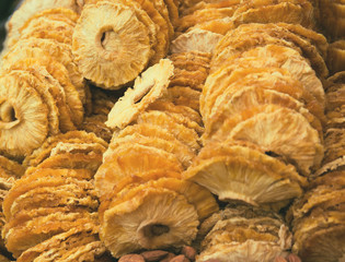 Slices of dried pineapple at the market close up. Tasty  snack suitable for vegeterians and vegans.