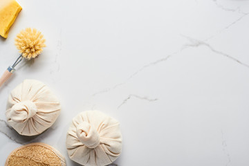 top view of spa fabric sacs, bath sponge and body brushes on marble surface