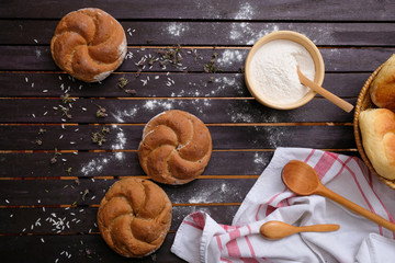 Black flour Kaiser rolls, wooden table