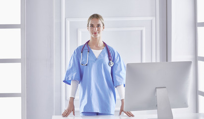 Portrait of a happy smiling young doctor in headset in office