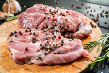Raw beef steak on a dark wooden table.