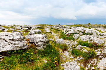 Poulnabrone Dolmen in Ireland, Uk. in Burren, county Clare. Period of the Neolithic with spectacular landscape. Exposed karst limestone bedrock at the Burren National Park. Rough Irish nature.