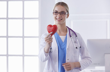 Doctor with stethoscope holding heart, isolated on white backgr