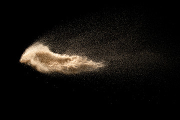 Dry river sand explosion isolated on black background. Abstract sand cloud.Brown colored sand...