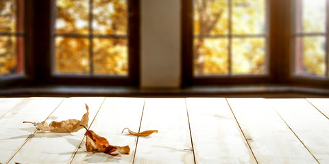Desk of free space and white table with autumn leaves 