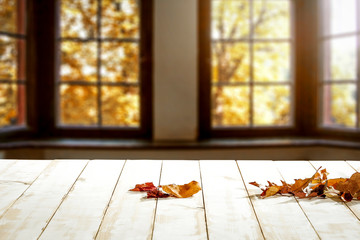Desk of free space and white table with autumn leaves 