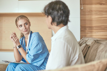 Obraz premium Friendly smiling doctor and patient sitting on the couch. Very