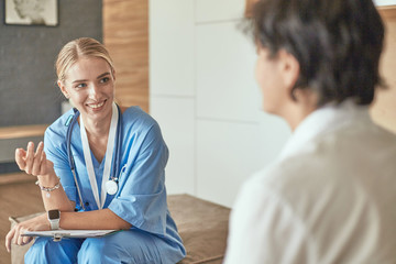 Fototapeta premium Friendly smiling doctor and patient sitting on the couch. Very