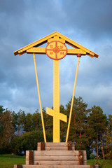 Wooden yellow christian orthodox cross near trees. Religious symbol. vertical