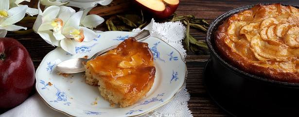 Homemade apple pie bathed with peach jam and honey. White flowers, jar of peach jam and honey. Fresh red apples and stevia leaves,