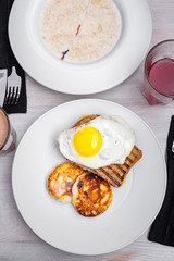 Tasty breakfast - omelette, toast, fried eggs, cheese pancakes on a white plate. Flat lay breakfast 