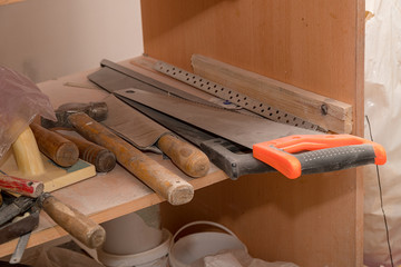 Carpenter's tools on the shelf. Saw, hammer, chisel, and so on. Selective focus