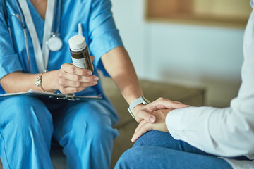 Beautiful smiling woman the doctor in a bottle of pill offers t