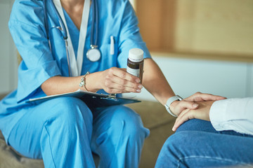 Beautiful smiling woman the doctor in a bottle of pill offers t