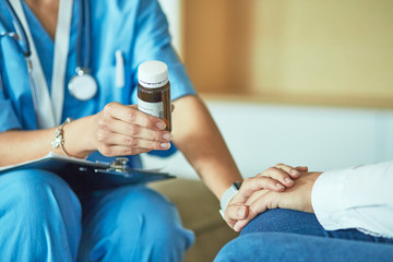 Beautiful smiling woman the doctor in a bottle of pill offers t