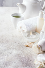 Obraz na płótnie Canvas White cosmetics face care frame with tea set on light stone background . Clean beauty concept