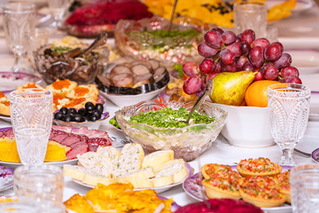 Served table. Snacks, fruits, sandwiches, salads, caviar and slicing on the holiday table. Selective focus