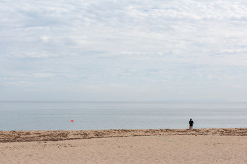 Una persona observa el paisaje en la playa