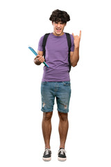 A full-length shot of a Young student man making rock gesture over isolated white background