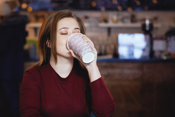 Young, pretty woman enjoys drinking coffee.