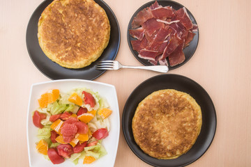 Spanish potato tortillas, ham and grapefruit salad in various dishes