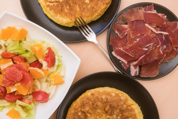 Spanish potato tortillas, ham and grapefruit salad in various dishes