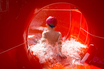 Little boy at the water slide on sun holidays
