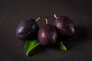 plums on black background