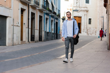 Young businessman is walking on the street with his backpack