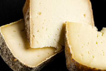 Variety of hard cheese on black background