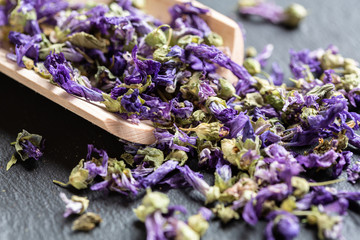 Mallow dried flowers on wooden scoop