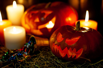 Halloween pumpkin and candles on a table with a straw