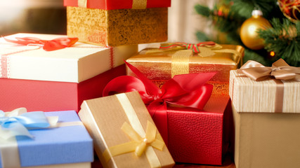 Macro image of colorful silk ribbons and bows on Christmas gifts boxes under Xmas tree