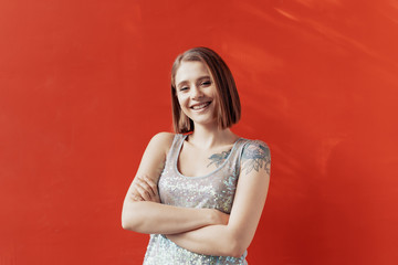 Cheerful young girl posing in front of a red wall