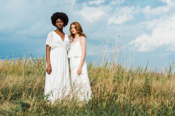 young attractive and multicultural women standing in field