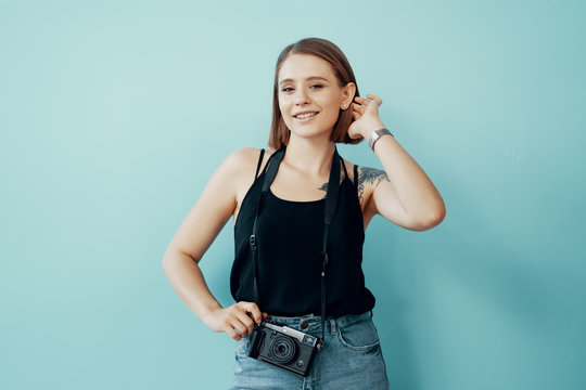 Young girl photographer taking photos on blue background